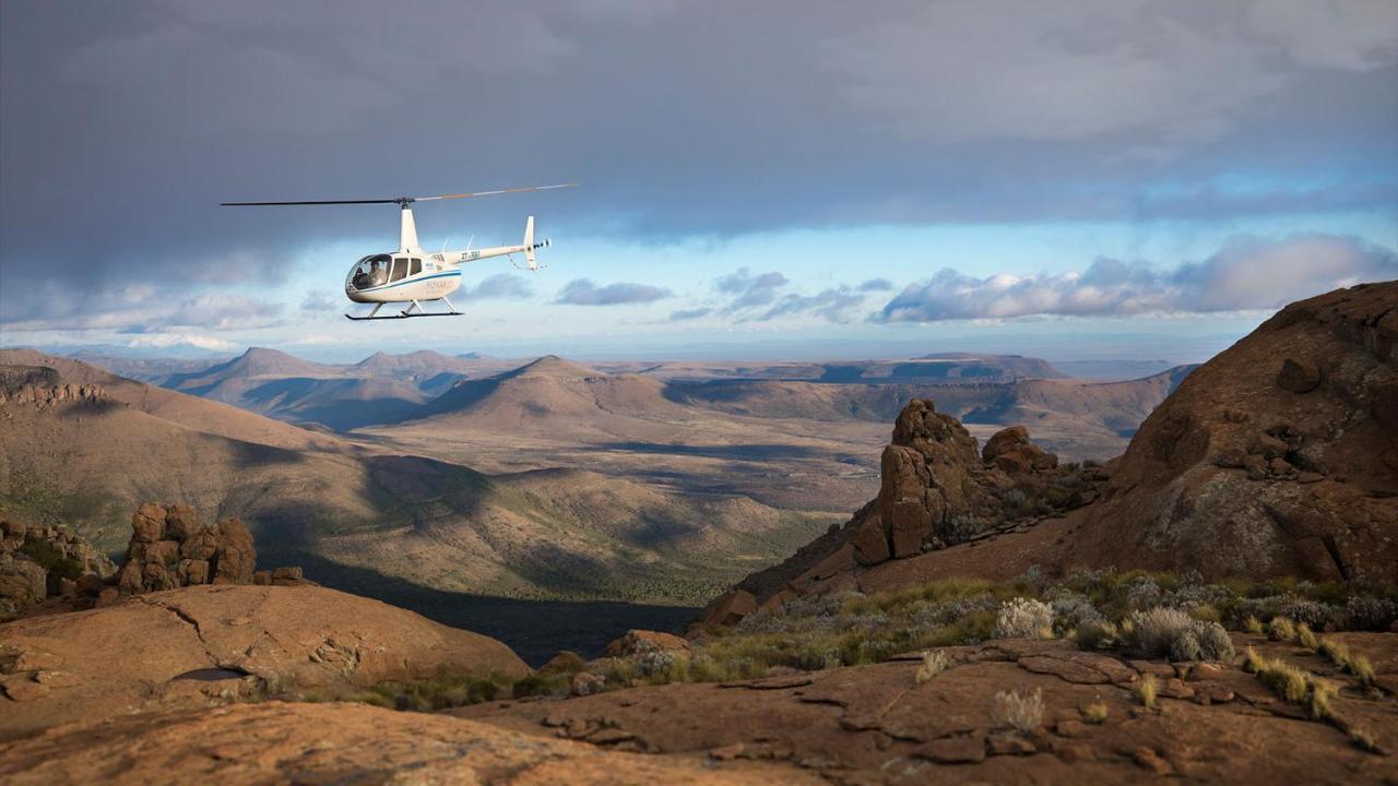 ドロスディー ホテル Graaff-Reinet エクステリア 写真 A Robinson R44 helicopter flying over the Namib Desert